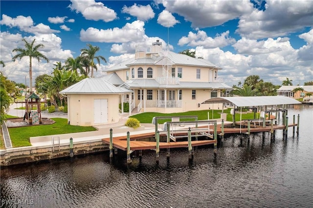 rear view of property featuring boat lift, a lawn, metal roof, and a water view