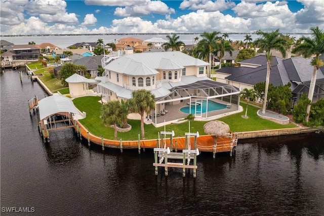 back of house with glass enclosure, a fenced in pool, a residential view, and boat lift