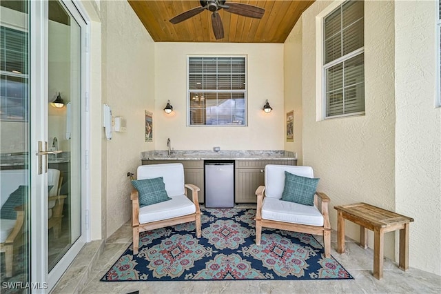 exterior space with wet bar, wooden ceiling, a textured wall, and a ceiling fan