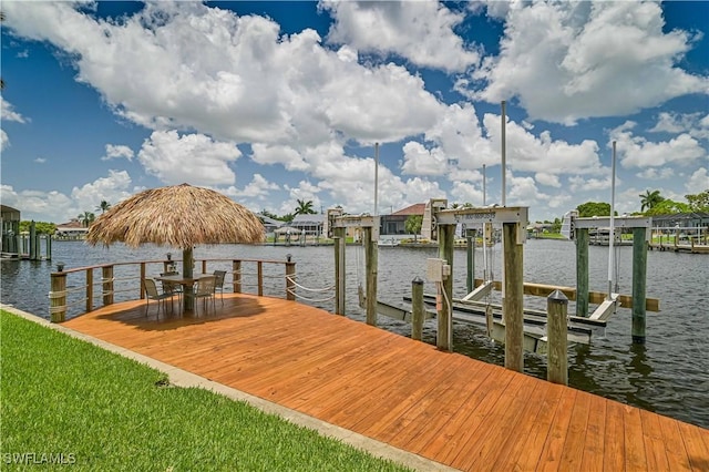 dock area featuring boat lift and a water view