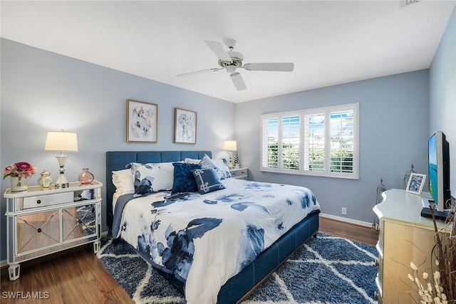 bedroom featuring dark wood finished floors, visible vents, baseboards, and ceiling fan