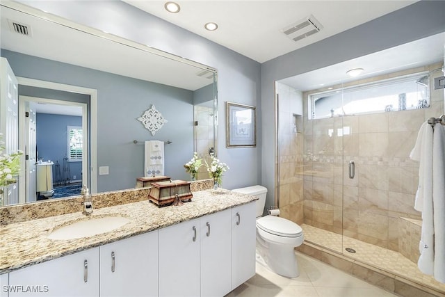 bathroom with vanity, toilet, visible vents, and a stall shower