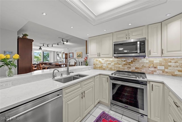 kitchen featuring light tile patterned flooring, decorative backsplash, appliances with stainless steel finishes, and a sink