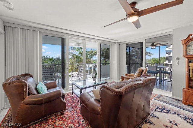 living area with light tile patterned floors, expansive windows, and a ceiling fan