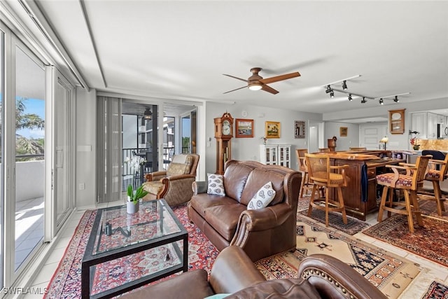 living room with light tile patterned flooring, plenty of natural light, and ceiling fan