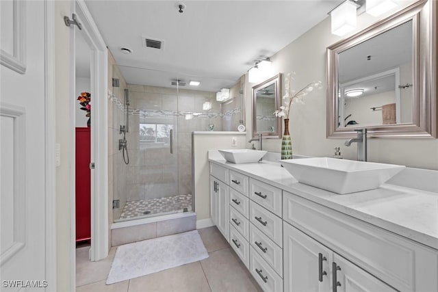 bathroom featuring double vanity, visible vents, a stall shower, and a sink