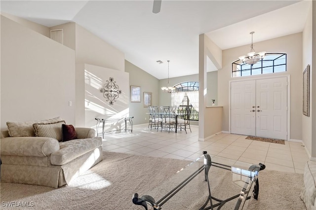 foyer with light tile patterned floors, baseboards, a notable chandelier, and high vaulted ceiling