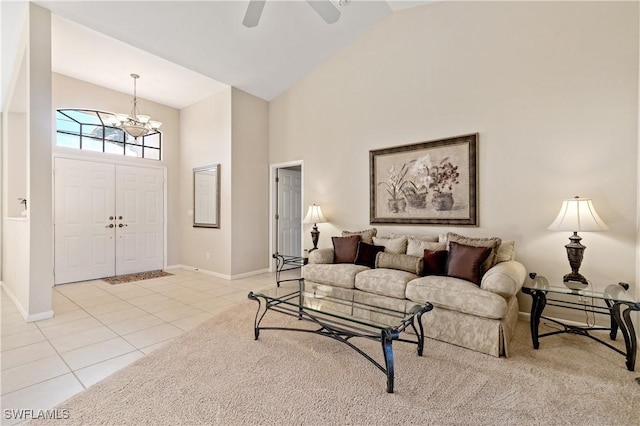 living room featuring light tile patterned flooring, ceiling fan with notable chandelier, baseboards, and high vaulted ceiling