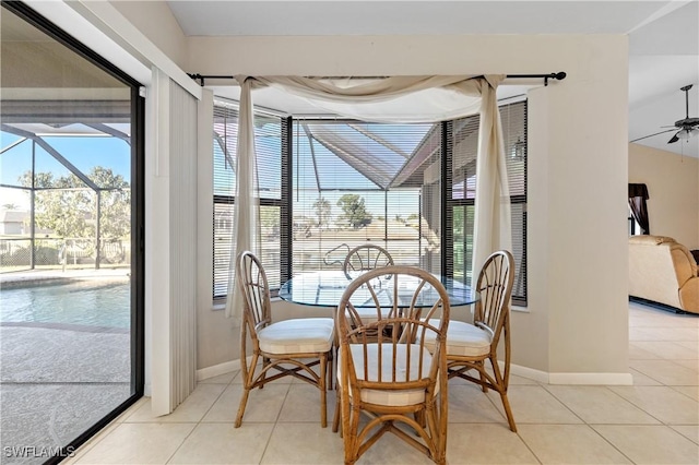 dining area with light tile patterned flooring, plenty of natural light, ceiling fan, and a sunroom