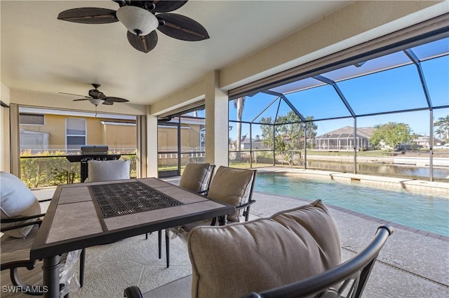 sunroom featuring a swimming pool, ceiling fan, and a water view