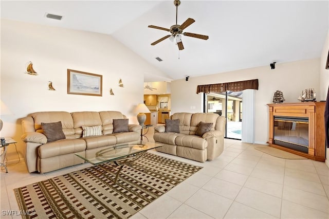 living area with light tile patterned flooring, visible vents, a ceiling fan, and a glass covered fireplace