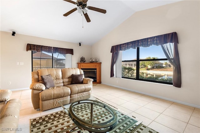 tiled living area with a glass covered fireplace, plenty of natural light, lofted ceiling, and ceiling fan