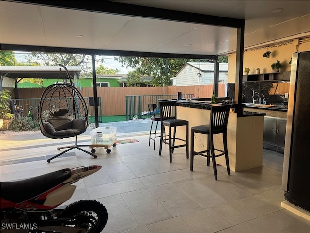 view of patio / terrace with outdoor wet bar and fence