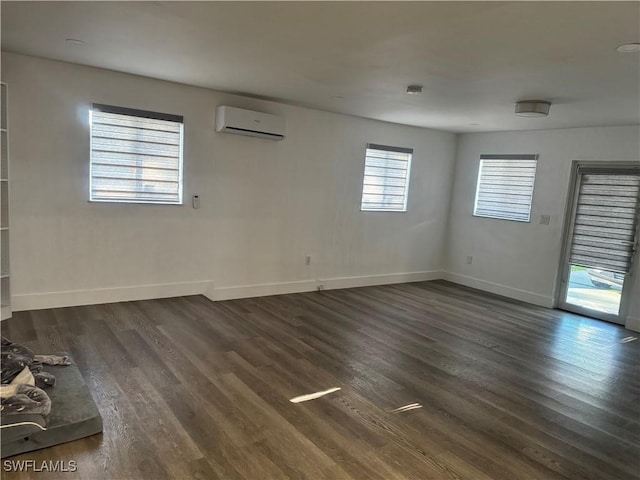 unfurnished room featuring dark wood-style floors, baseboards, and a wall mounted AC