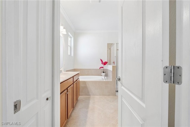 bathroom featuring tile patterned flooring, vanity, a garden tub, and ornamental molding