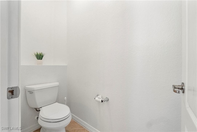 bathroom with tile patterned flooring, toilet, and baseboards