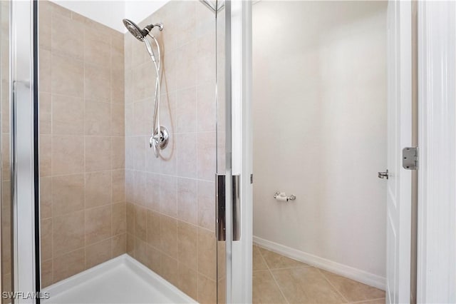 bathroom with tile patterned flooring, a stall shower, and baseboards