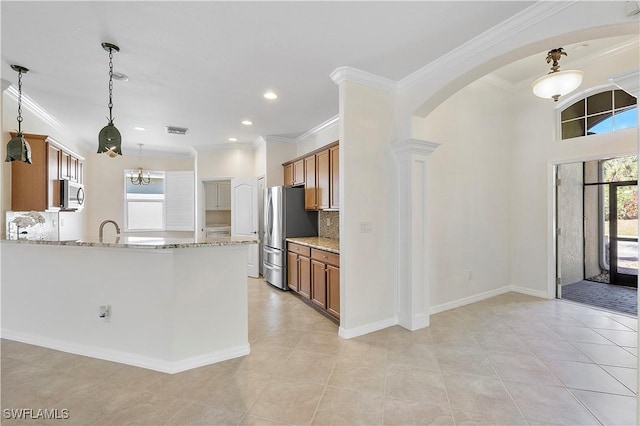 kitchen with light stone counters, stainless steel appliances, arched walkways, and brown cabinetry