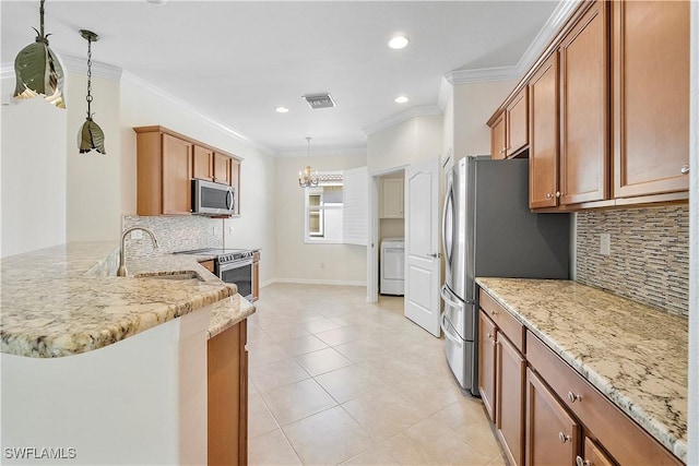 10432 Yorkstone Dr, Bonita Springs, FL 34135 - kitchen featuring stainless steel appliances, washer / dryer, light stone countertops, backsplash, and ornamental molding