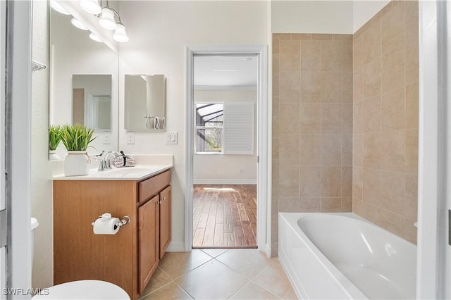 full bathroom featuring tile patterned flooring, toilet, vanity, and baseboards