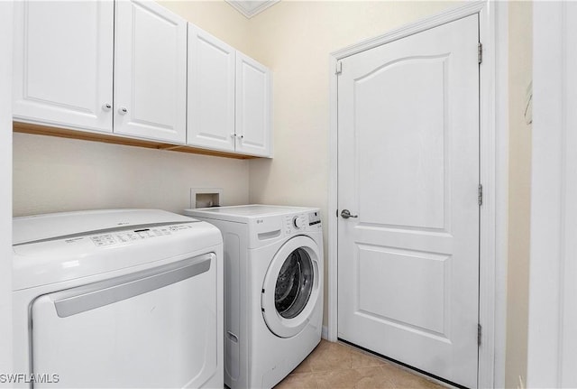 washroom featuring light tile patterned flooring, cabinet space, and washing machine and clothes dryer