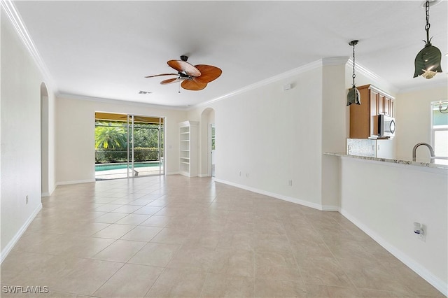 unfurnished living room with light tile patterned floors, baseboards, ceiling fan, and ornamental molding