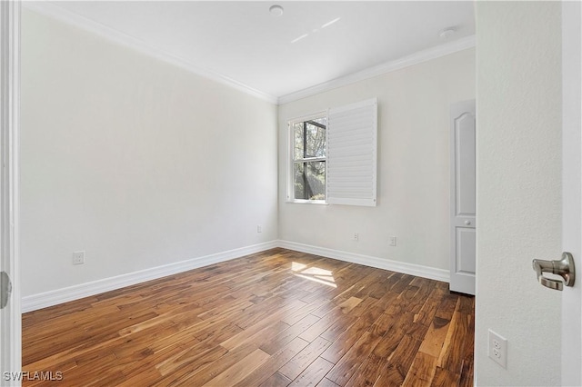 unfurnished room with crown molding, wood finished floors, and baseboards