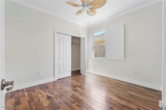 unfurnished bedroom with baseboards, ornamental molding, wood finished floors, a closet, and a ceiling fan