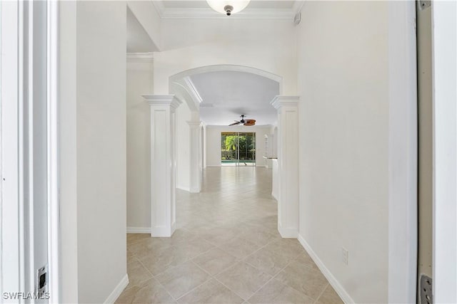 hallway with baseboards, arched walkways, ornamental molding, and ornate columns