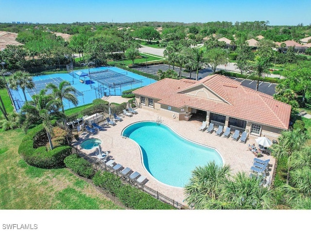 community pool with a patio and fence