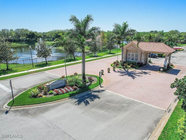 exterior space featuring curbs, a water view, and street lights