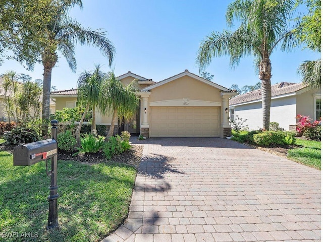 view of front facade featuring stucco siding, decorative driveway, and an attached garage