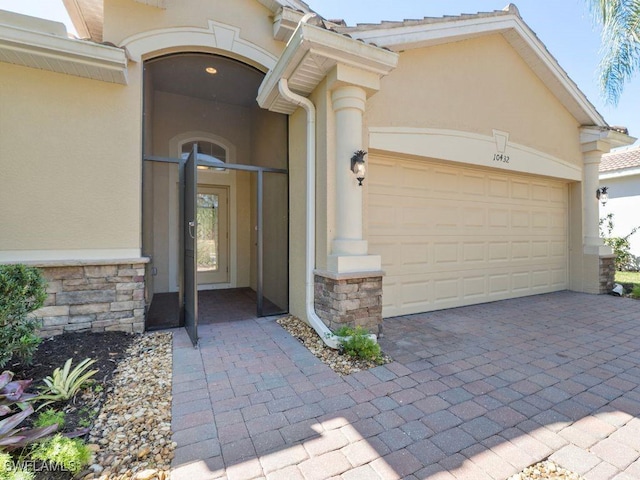 10432 Yorkstone Dr, Bonita Springs, FL 34135 - entrance to property with stucco siding, stone siding, an attached garage, and driveway