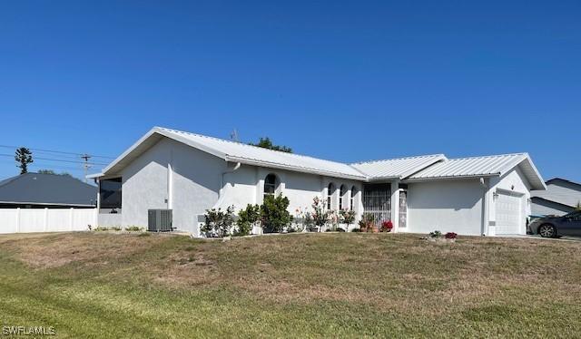 view of front of house featuring stucco siding, central AC, an attached garage, and metal roof