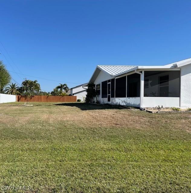 view of yard featuring fence and a sunroom