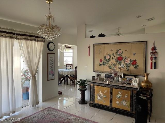 hallway featuring light tile patterned floors, a notable chandelier, and visible vents