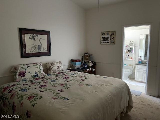 bedroom featuring light colored carpet and ensuite bathroom