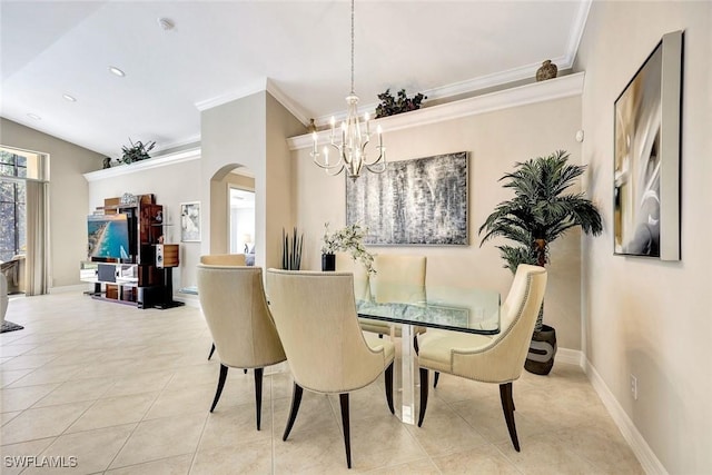 dining room with tile patterned floors, arched walkways, an inviting chandelier, crown molding, and baseboards