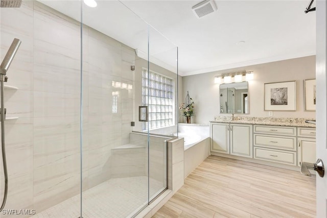 bathroom featuring visible vents, a shower stall, crown molding, a bath, and vanity