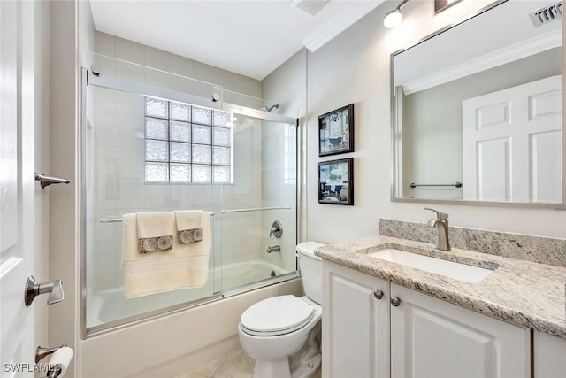 full bathroom featuring visible vents, toilet, combined bath / shower with glass door, crown molding, and vanity