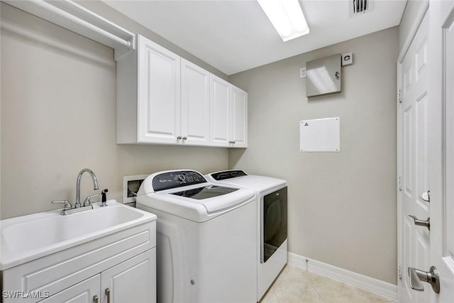 washroom with visible vents, a sink, cabinet space, separate washer and dryer, and baseboards