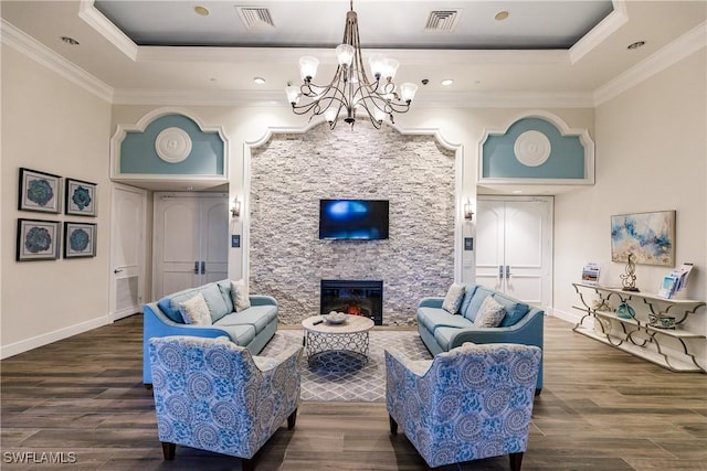 living room featuring a raised ceiling, a notable chandelier, visible vents, and ornamental molding