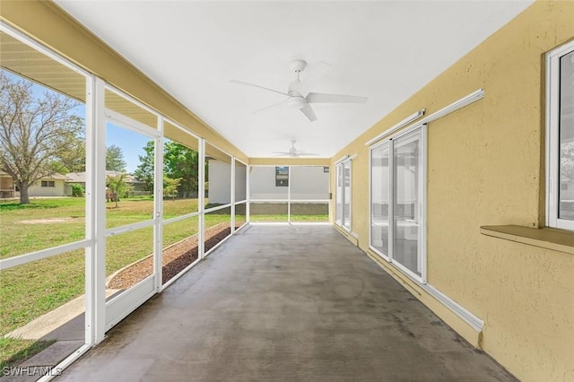 unfurnished sunroom with ceiling fan