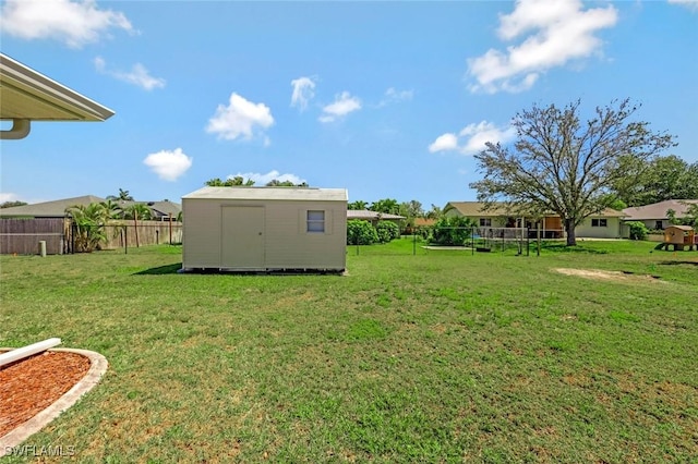 view of yard featuring a storage shed, an outbuilding, and fence