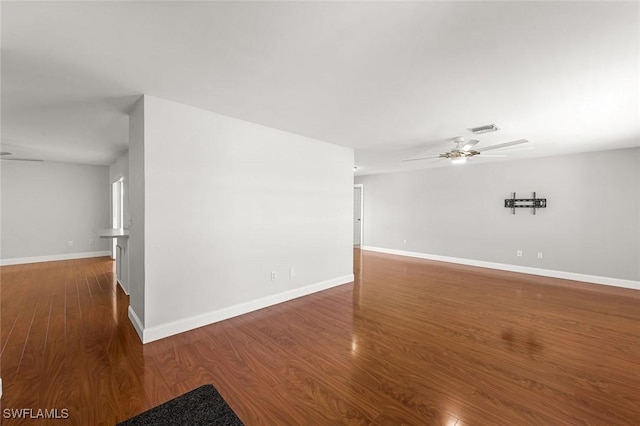 empty room with visible vents, baseboards, ceiling fan, and wood finished floors