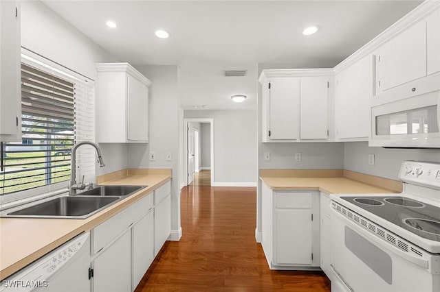 kitchen with white cabinetry, white appliances, visible vents, and a sink