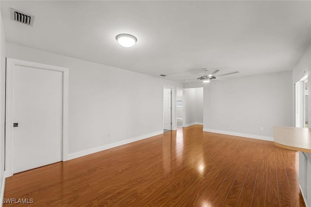 unfurnished room with visible vents, ceiling fan, baseboards, and wood finished floors