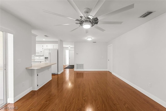 unfurnished living room featuring dark wood-style floors, visible vents, and baseboards