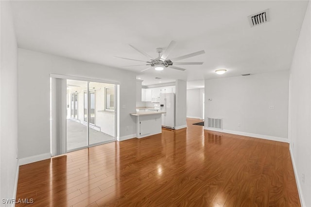 unfurnished living room with visible vents, ceiling fan, and wood finished floors