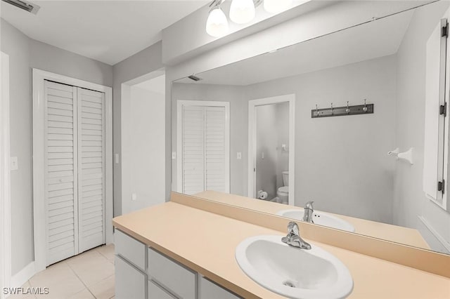 bathroom with visible vents, tile patterned floors, toilet, a closet, and vanity